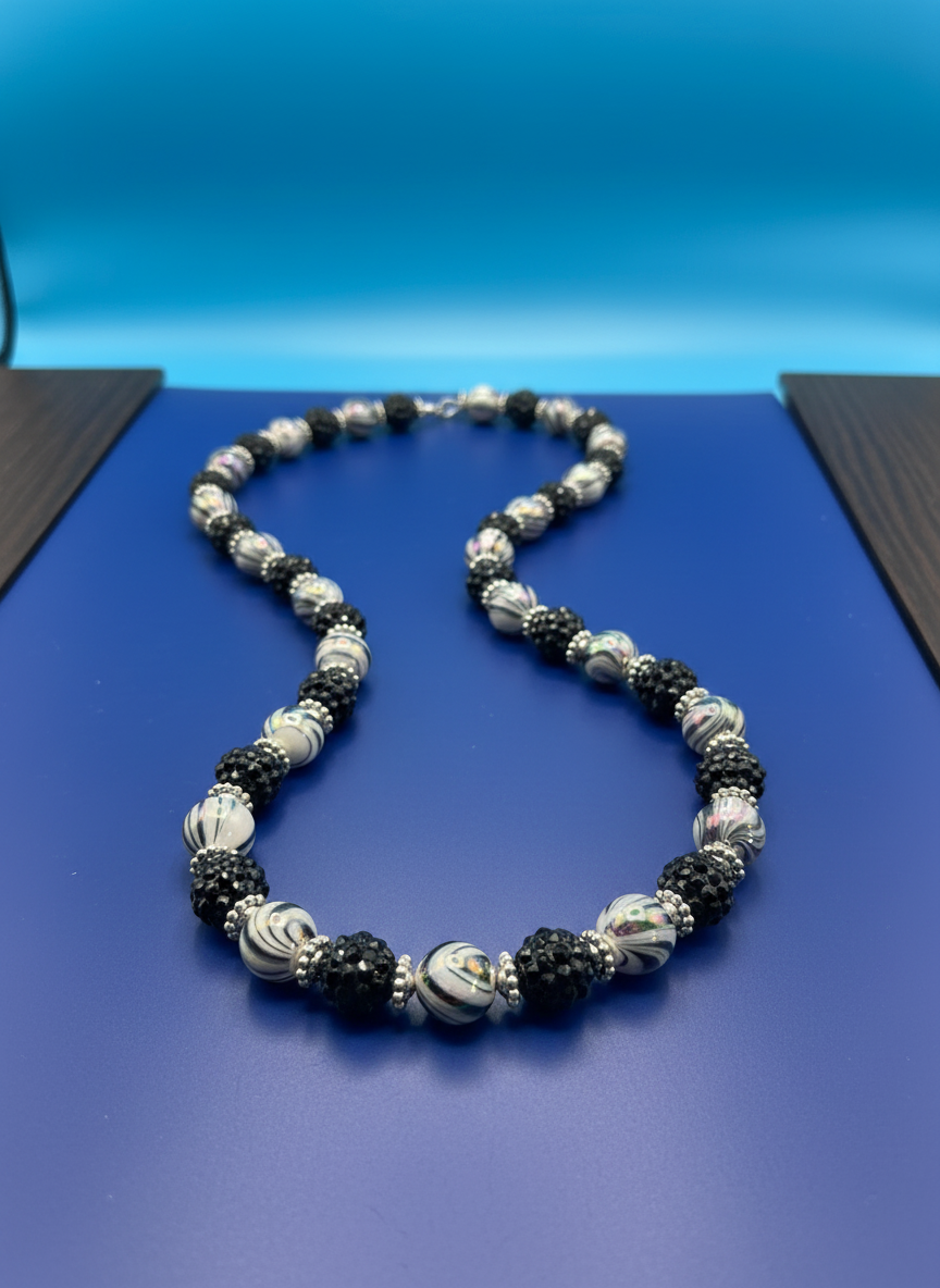 Midnight Whirl Necklace on blue background - shot 3